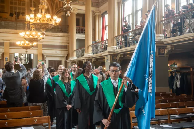 People carrying flags in the university aula