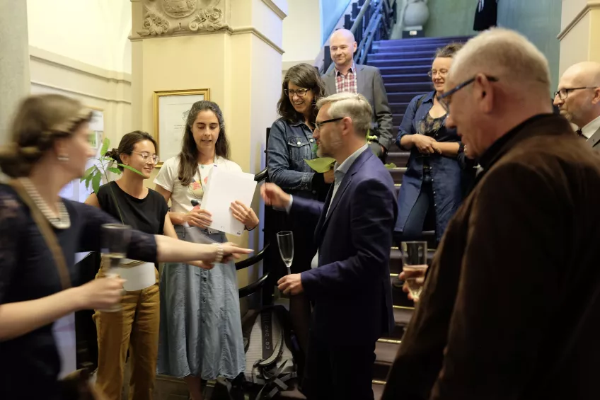 Gathering in the reception with colleagues standing around Björn. Photo. 