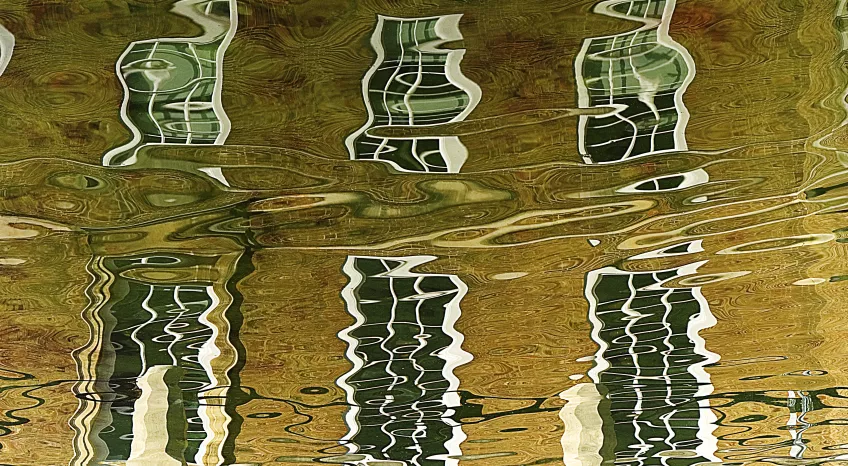 A pciture of windows reflected in wavy water 