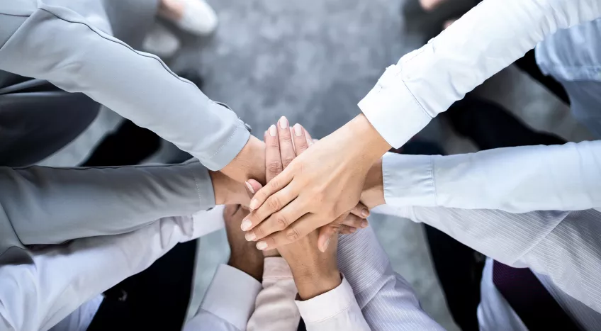 A photo taken from above of hands on top of each other 